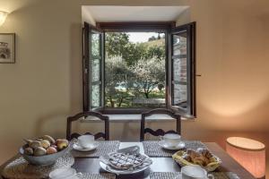 einen Tisch mit einer Schüssel Essen und einem Fenster in der Unterkunft Borgo Al Cerro in Casole dʼElsa