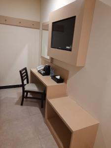 a room with a desk with a television and a chair at Jakarta City Hotel in Jakarta