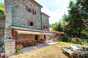 un bâtiment avec une table et des chaises devant lui dans l'établissement Poet's Rest, à Pieve Santo Stefano