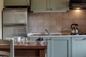 a kitchen with a sink and a table with a bowl of fruit at Borgo Al Cerro in Casole dʼElsa