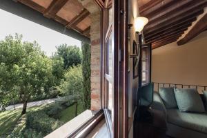 a room with a window with a couch and a view at Borgo Al Cerro in Casole dʼElsa