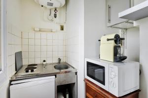 a small kitchen with a stove and a sink at Studio cosy bressan in Bourg-en-Bresse