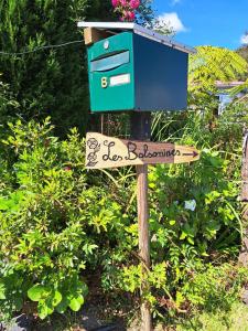 un panneau de rue avec une boîte aux lettres bleue en haut dans l'établissement Les Balsamines chez Michèle & Daniel, à La Plaine-des-Palmistes