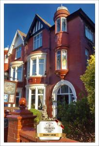 a red brick building with a clock tower on it at Pembroke Bed & Breakfast in Blackpool