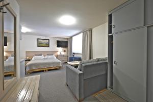 Habitación de hotel con cama y sofá en POKOJE "CICHA" ZAKOPANE en Zakopane