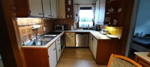 a small kitchen with white cabinets and a sink at Arrive & Relax - Volkmar in Düsseldorf