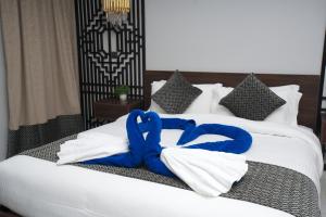 YM Resort في ينبع: سرير عليه مناشف زرقاء وبيضاء