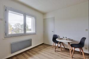 a room with a table and two chairs and a window at Studio cosy bressan in Bourg-en-Bresse