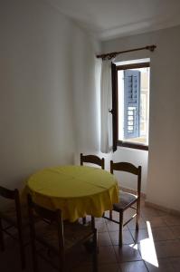 uma sala de jantar com uma mesa e cadeiras e uma janela em Apartments Ivanis em Vrsar