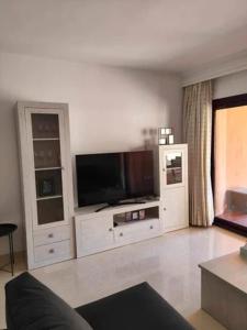 a living room with a flat screen tv at Jardines de Albaicin - La Aldorra in Estepona