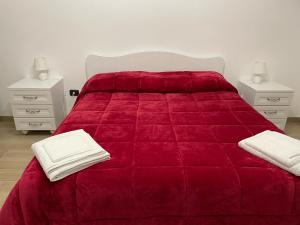 a bedroom with a red bed with two night stands at MARTA'S APARTMENT ROCCARASO in Roccaraso