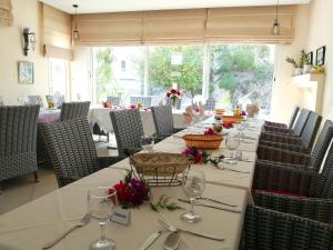 a dining room with a long table with wine glasses at Hôtel Romane in Hammamet