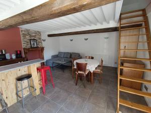 a room with a table and chairs and a couch at La petite maison in Planchez