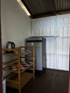 a small kitchen with a refrigerator and a table at Hidden Viewpoint House in Mae Haad