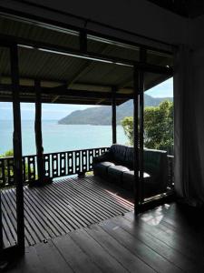 a couch on a deck with a view of the water at Hidden Viewpoint House in Mae Haad