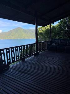 a wooden porch with a view of the water at Hidden Viewpoint House in Mae Haad