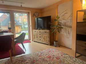 a living room with a flat screen tv and a table and chair at Wellness Oase auf dem Land in Buttstädt