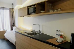 a kitchen with a sink and a couch in a room at Athens Lodge by Athens Prime Hotels in Athens