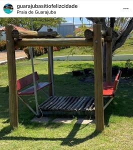 a swing in a park with a chair at Guarajuba sitiofelizcidade in Guarajuba
