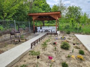einen Garten mit einem Pavillon mit einem Tisch und Blumen in der Unterkunft Vila Elisa 