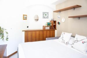 1 dormitorio con 1 cama blanca con sábanas blancas en STUDIOLAKE by Design Studio, en Bellano