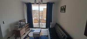 uma sala de estar com uma televisão e uma varanda em Departamento de 2 dormitorios y 1 baño em Arica