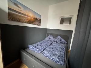 a small bedroom with a bed and two pillows at RB City Apartments Emden am Wall 2 in Emden