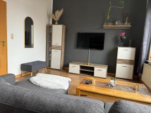 a living room with a couch and a tv at RB City Apartments Emden am Wall 2 in Emden