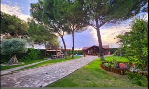 a park with trees and a walkway with benches at "Pequeño Paraiso" Cabaña con Jacuzzi y piscina privada in Traspinedo