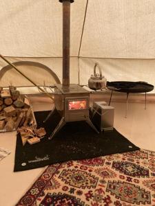 a stove sitting on a rug in a room at Winter Glamping Tent Hovfjallet Vitsand in Torsby