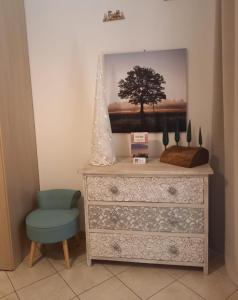 een dressoir en een stoel met een foto aan de muur bij GLI ALBERI apartment with view in Montepulciano