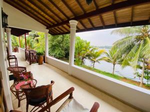 a porch with chairs and a view of the water at River Shadow Villa in Bentota