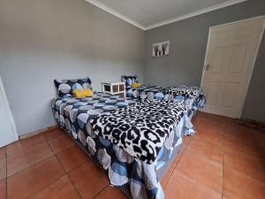two twin beds in a room with at Woodhills Guest house in Piet Retief