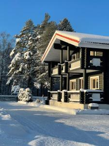un edificio con nieve en el suelo junto a los árboles en Villa Uuekadaka en Põhja