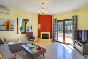 a living room with a couch and a tv at Villa Aloni in Boïkátika