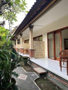 a porch of a house with a bench on it at Nataliya Homestay in Ubud