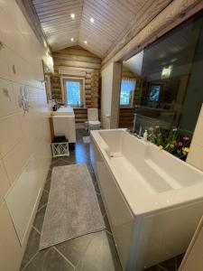 ein Badezimmer mit einer großen Badewanne und einem Waschbecken in der Unterkunft Villa Uuekadaka in Põhja