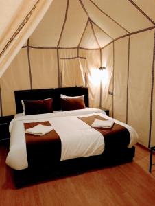 a bedroom with a large bed in a tent at Merzouga Wildlife Desert Camp in Merzouga