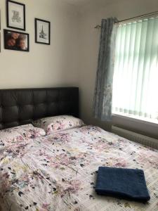 a bedroom with a bed with a blanket and a window at House in Hounslow
