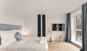 ein weißes Schlafzimmer mit einem großen Bett und einem Fenster in der Unterkunft Modernes Apartment am Gleispark in Oldenburg