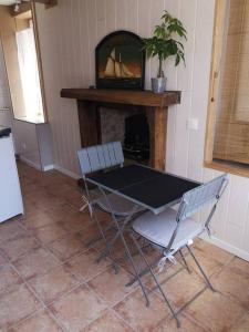 a table and two chairs in a room with a fireplace at La coco's house in Planchez +5 photos