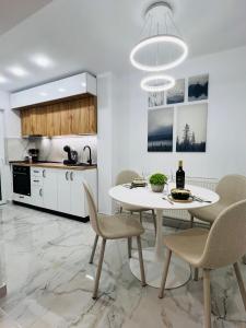 a kitchen and dining room with a table and chairs at MarbleHome~Straja/Lupeni in Lupeni