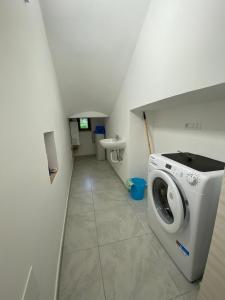 eine Waschküche mit Waschmaschine und Waschbecken in der Unterkunft Casa concy in Sant'Agnello