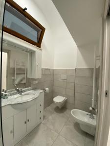 een witte badkamer met een wastafel en een toilet bij Casa concy in Sant'Agnello