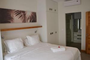 1 dormitorio con 1 cama blanca y 2 almohadas blancas en Spacieux appt 2ch 50m de la plage, en Cap Malheureux