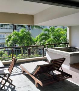 a patio with two chairs and a table on a balcony at Spacieux appt 2ch 50m de la plage in Cap Malheureux