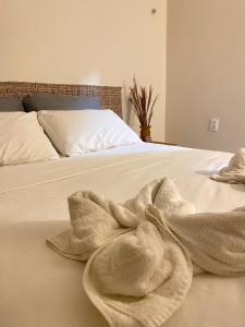 a white bed with a blanket on it at Pousada Vibe Guajiru in Trairi