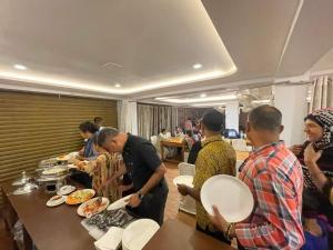 a group of people standing around a table with food at Hotel Sundaram Palace in Siliguri