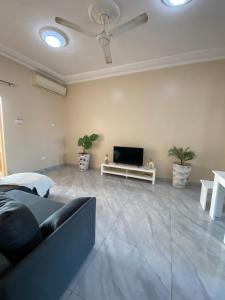 uma sala de estar com um sofá e uma televisão de ecrã plano em KMR Apartment - Kumba em Serekunda