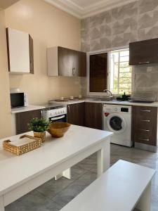 eine Küche mit einer weißen Arbeitsplatte in einem Zimmer in der Unterkunft KMR Apartment - Kumba in Serekunda